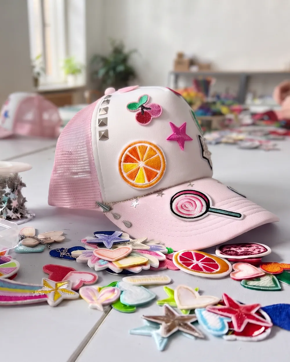 Mit Patches, Nieten und Sternchenkette gestaltete Trucker-Cap auf einem Tisch beim Team-Event